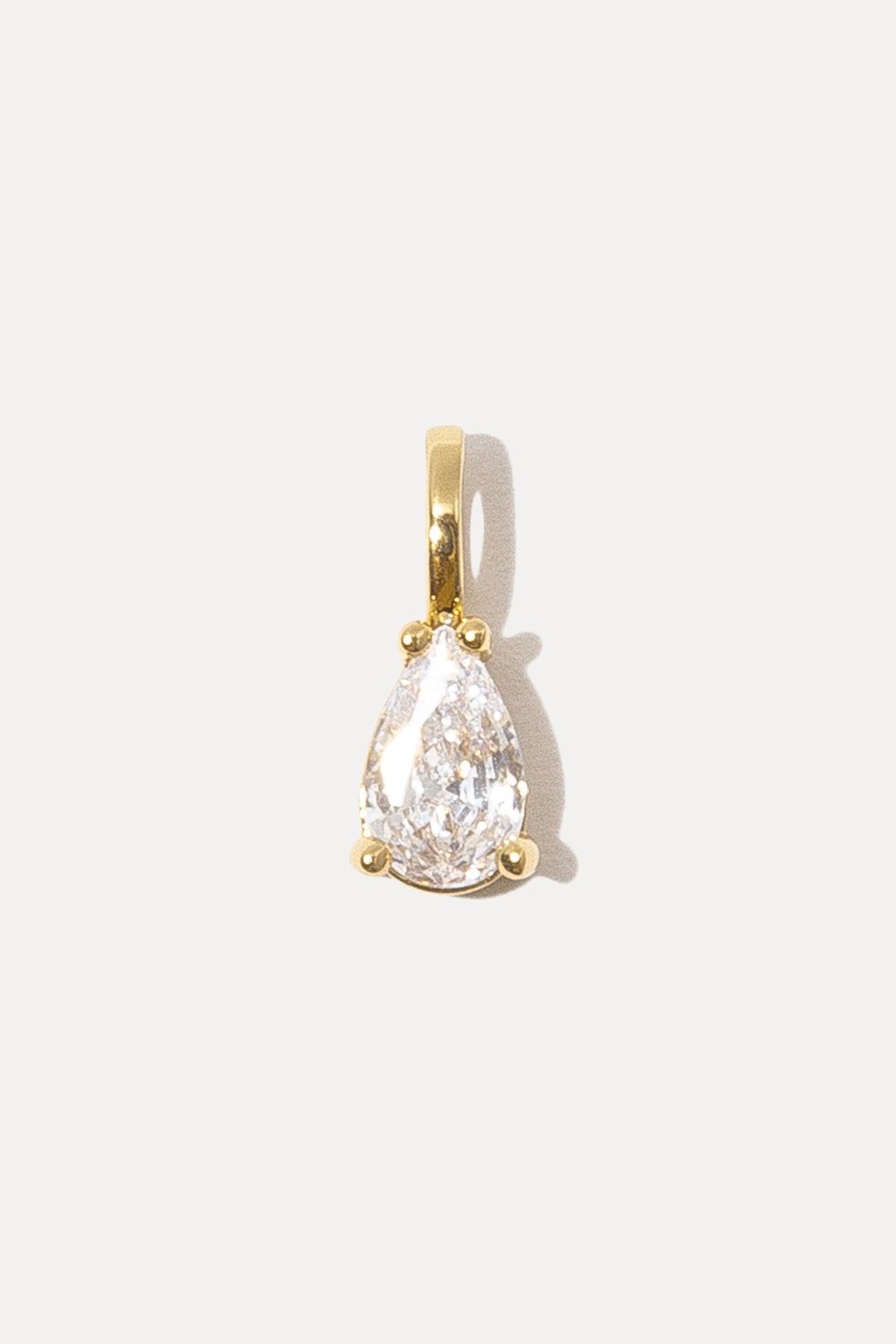 Gold Gianna Charm with a pear-shaped cubic zirconia stone on a white background.