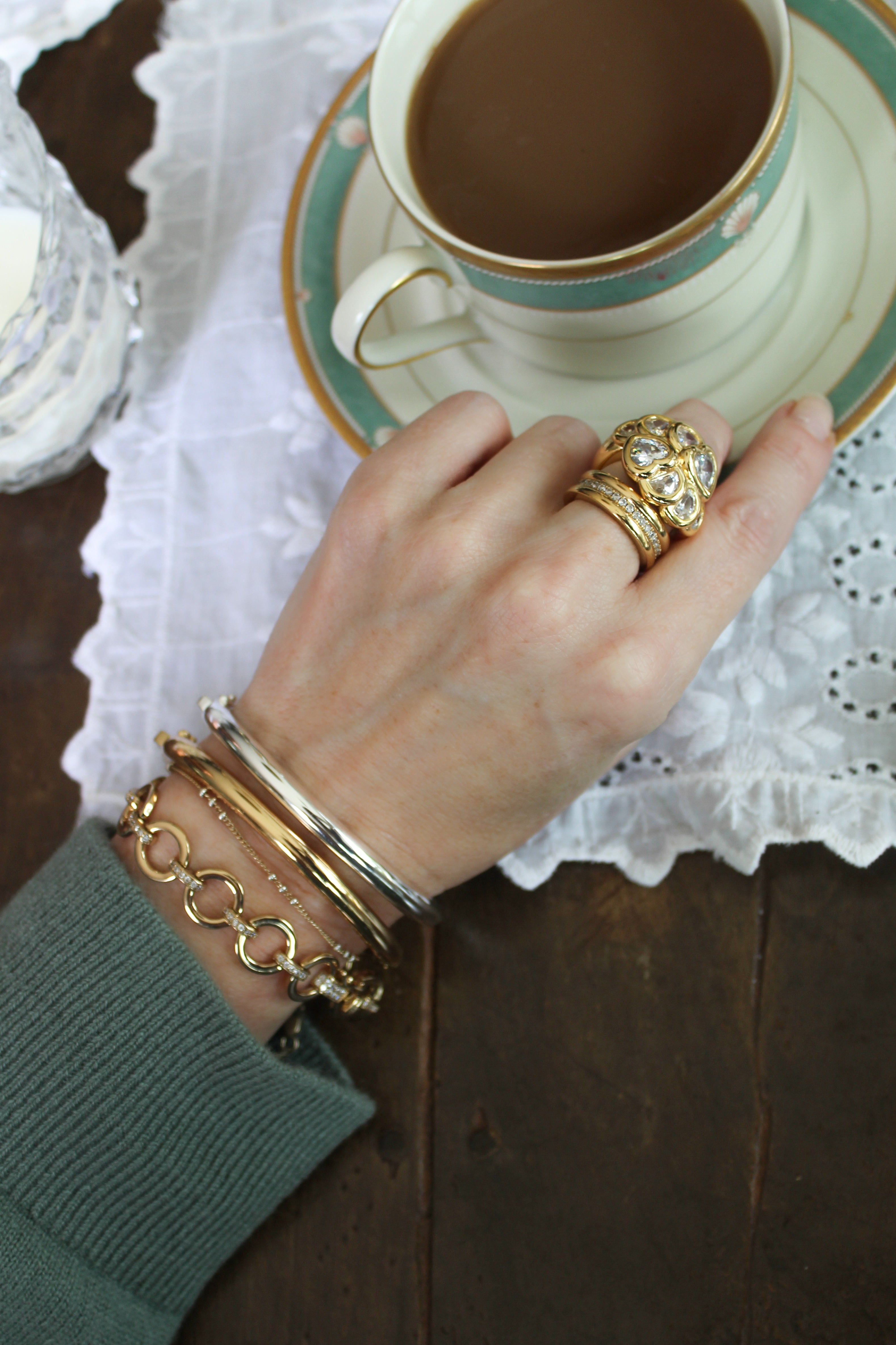 Model wearing the gold aria bracelet and mina cuffs in gold and silver paired with the bardot and Ariana Ring in gold.