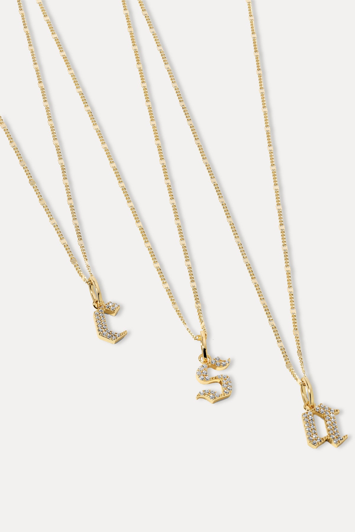 Gold gothic font initial pendant attached to a gold chain displayed against a plain white background.