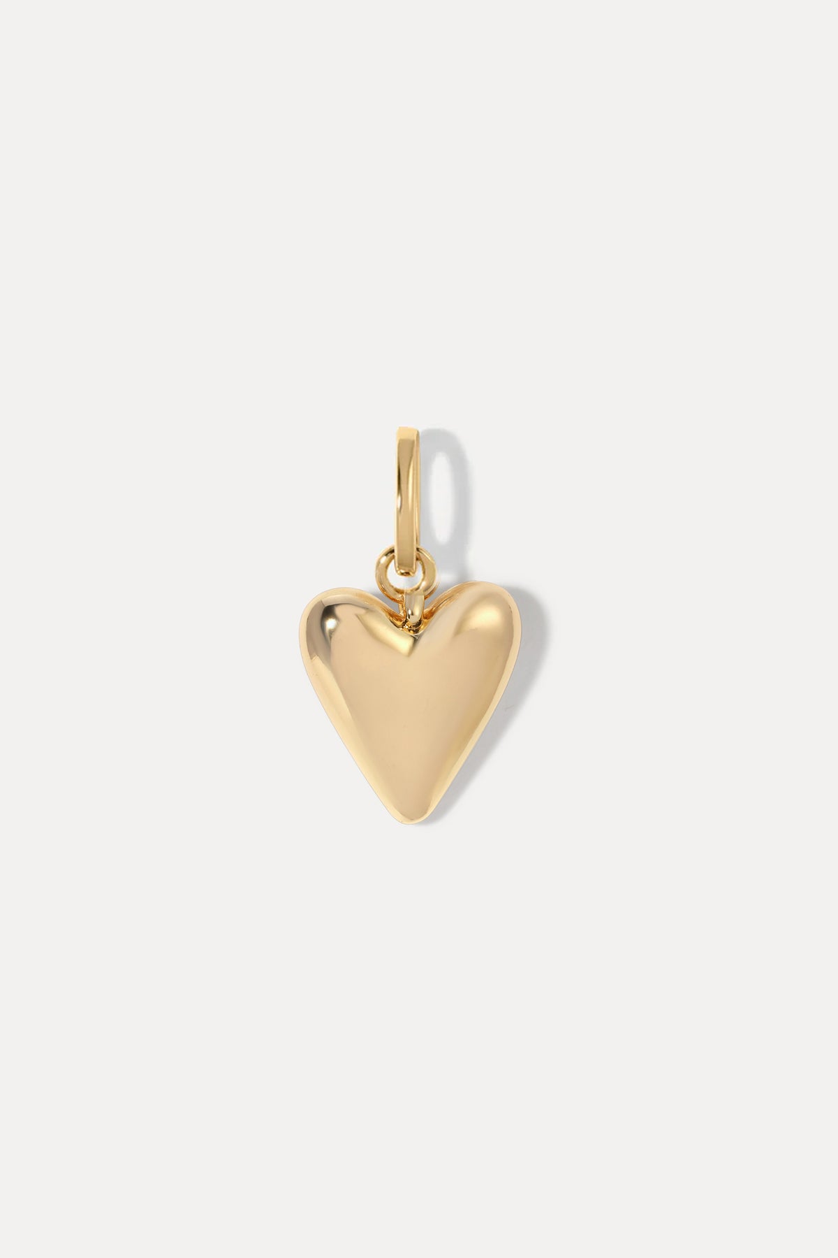 Gold puffy heart necklace charm on a bail against a white background.
