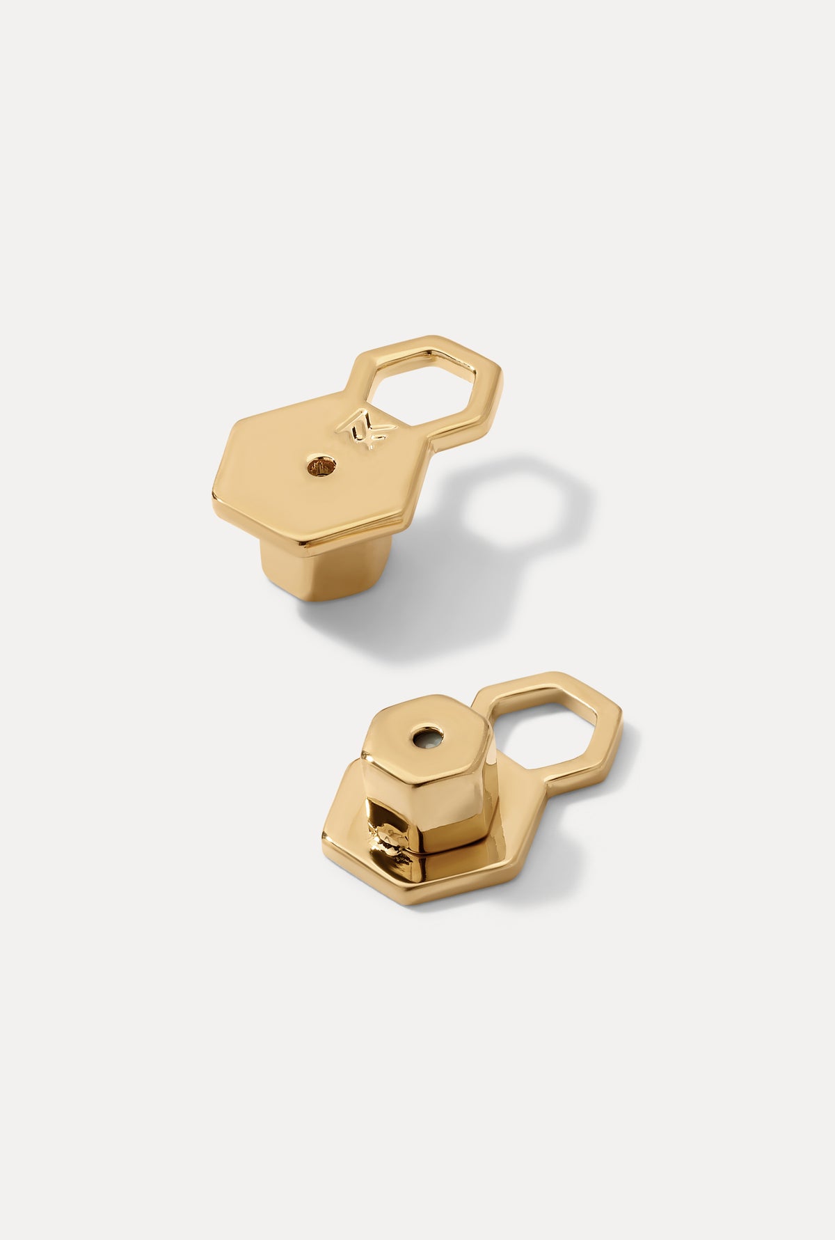 Image of the MF support earring backs in gold on a white background.