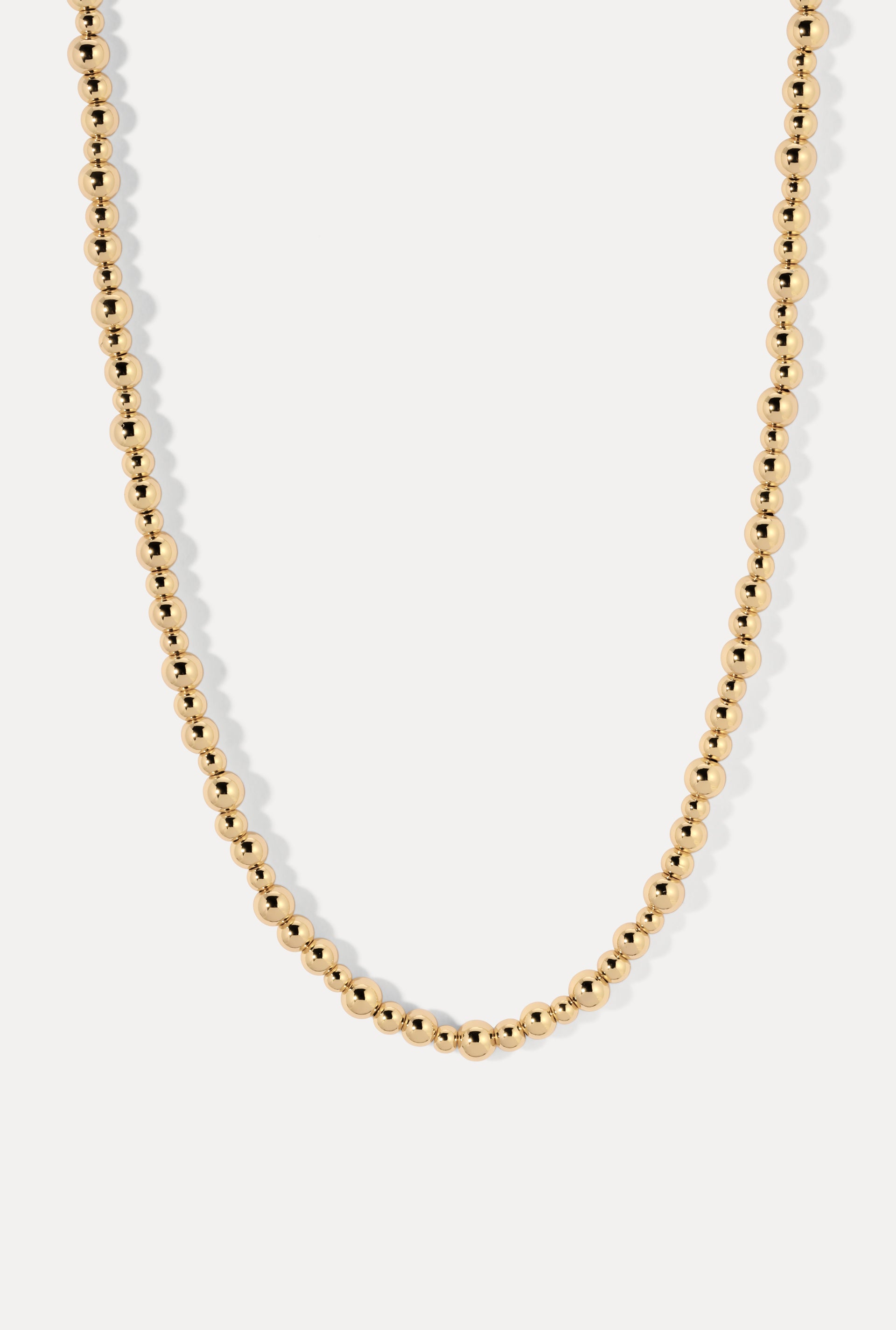 Gold Marina necklace with graduated ball chain beads, displayed on a clean white background.