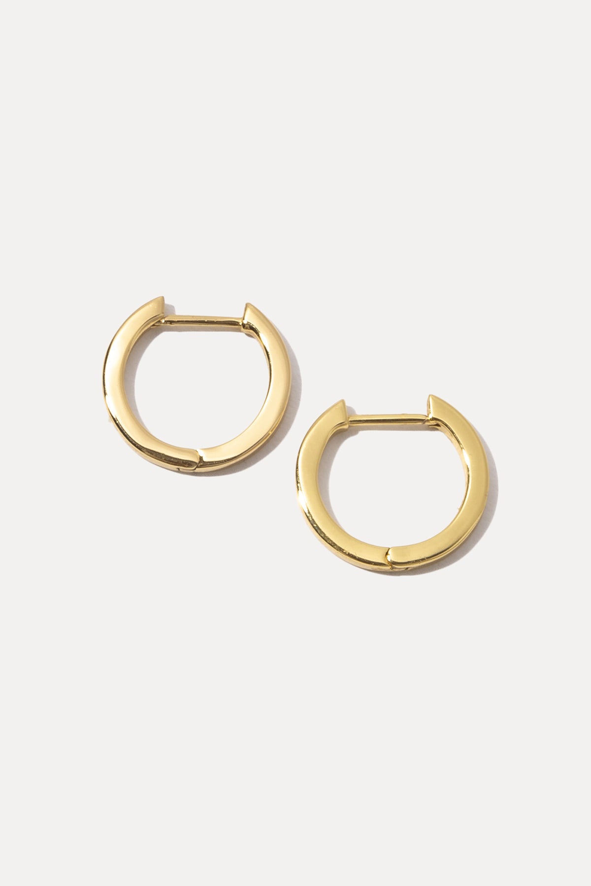 Pair of gold Mel Huggies featuring a smooth, classic hoop design on white background.