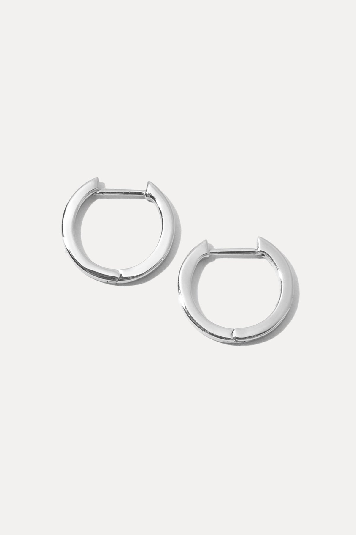 Pair of silver Mel Huggies featuring a smooth, classic hoop design on white background.