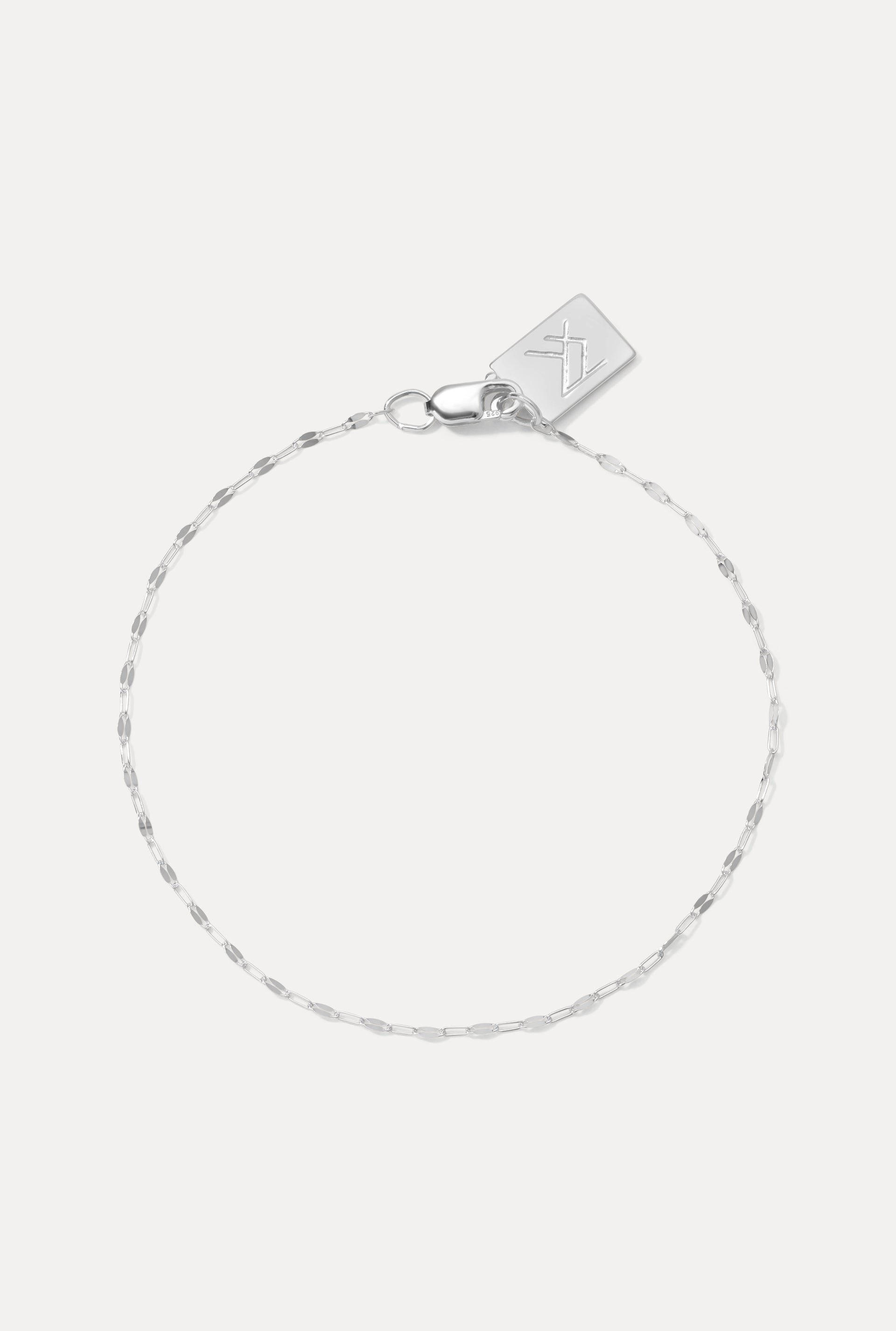 Sterling silver Nora sequin chain bracelet displayed in a circle on a white background with logo tag.