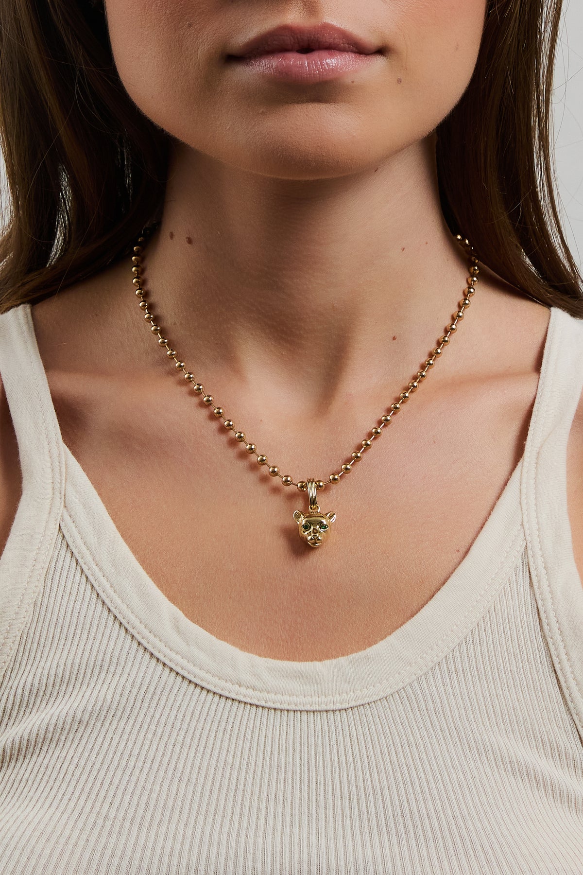 Model wearing gold Panther Charm on amelia necklace, styled with a cream ribbed tank top.