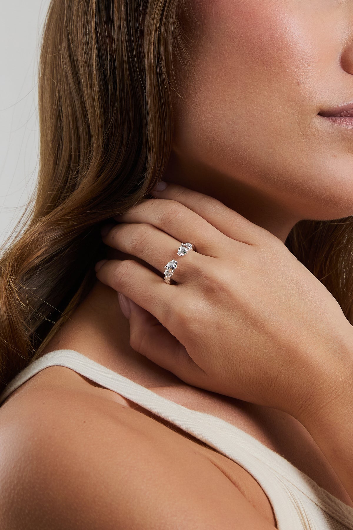 Close-up of model wearing silver Panther Ring on index finger in a cream ribbed top.