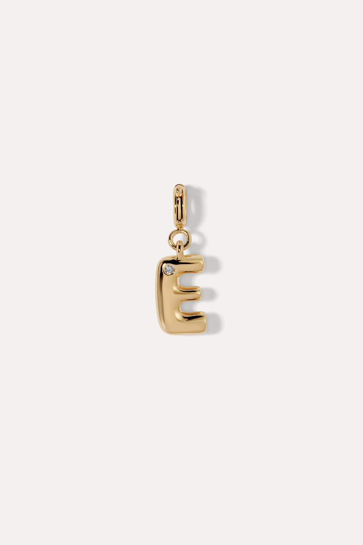 Gold puffy initial clip-on charm in the letter E with a crystal accent and hinged clip bail against a plain white background.