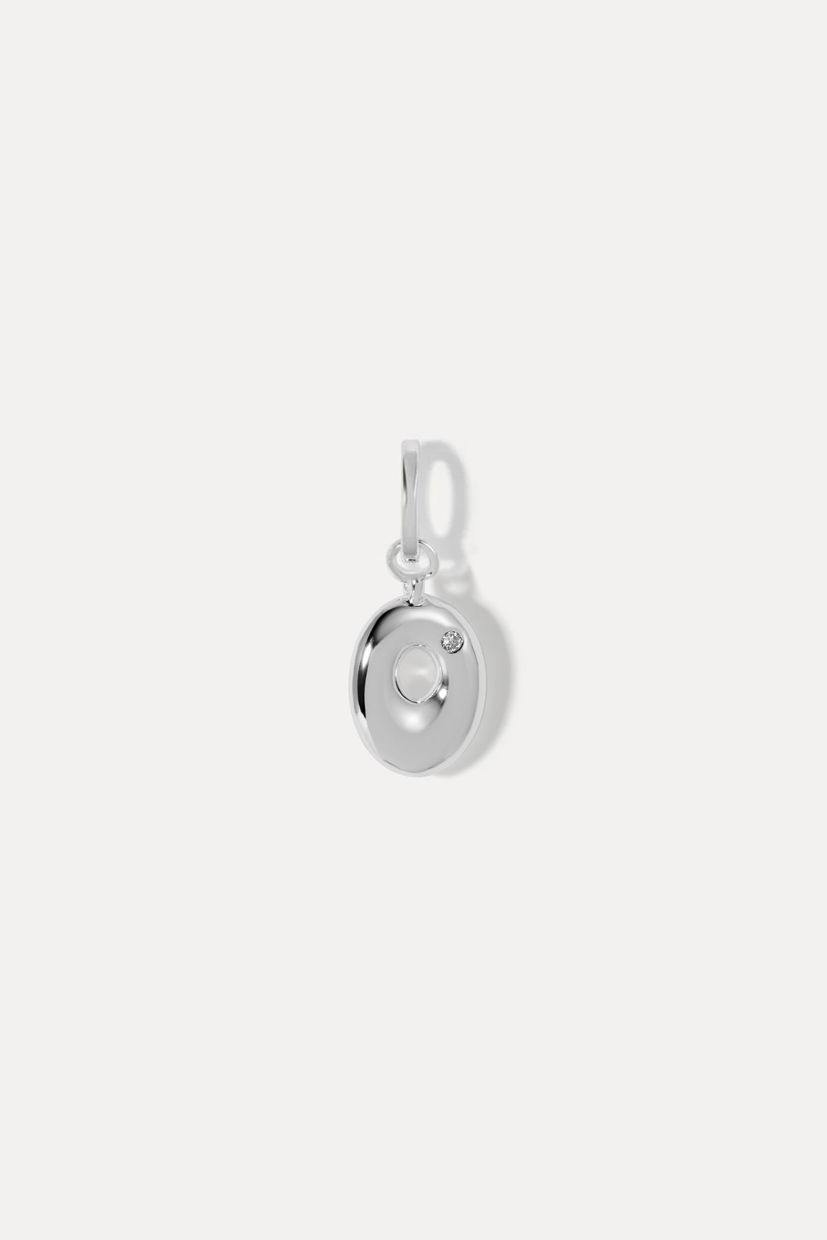 Silver puffy initial letter O with clear stone set on a standard ring bail against white background.