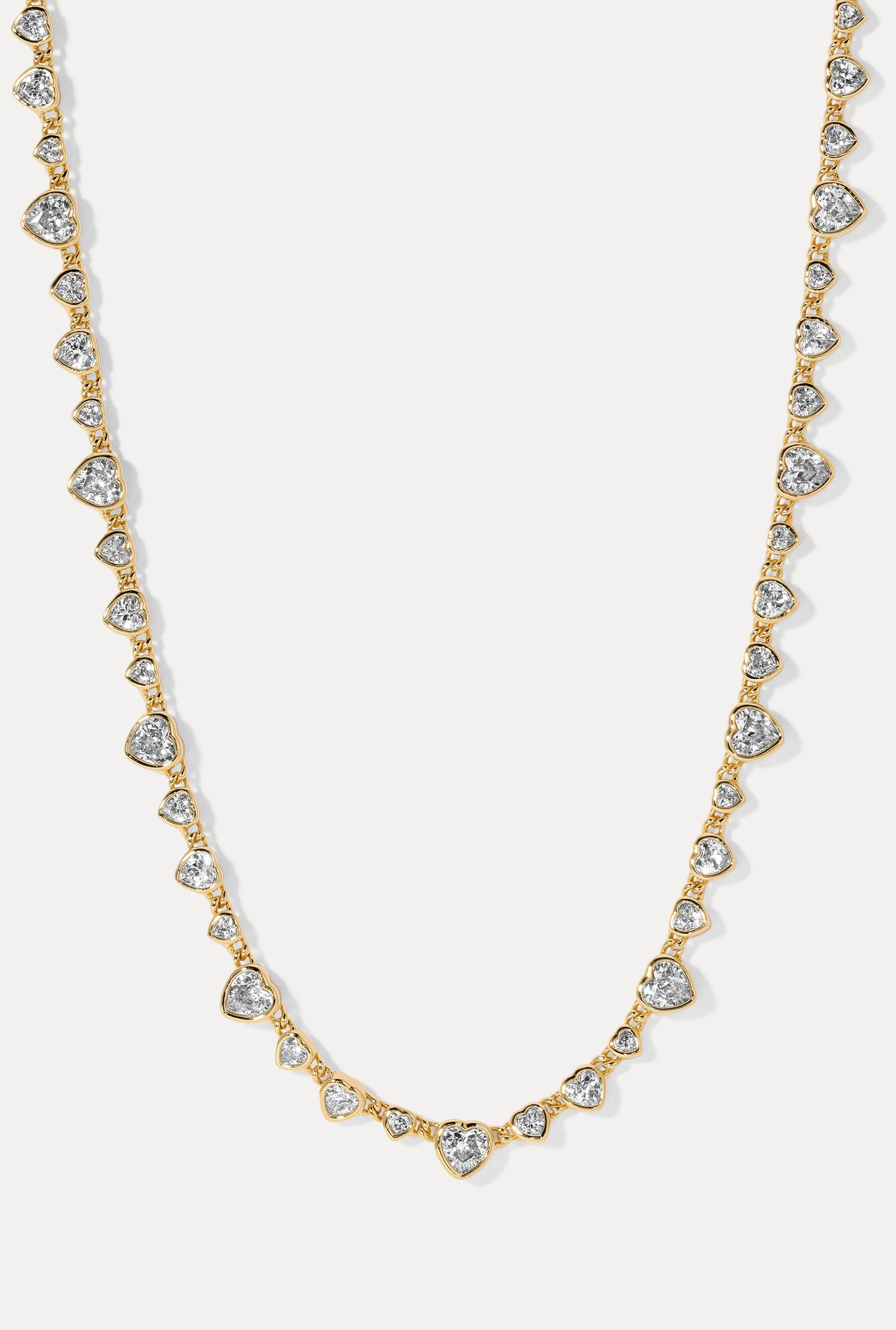 Cora Gold Necklace with round CZ heart links in a U-shape loop on a white background.