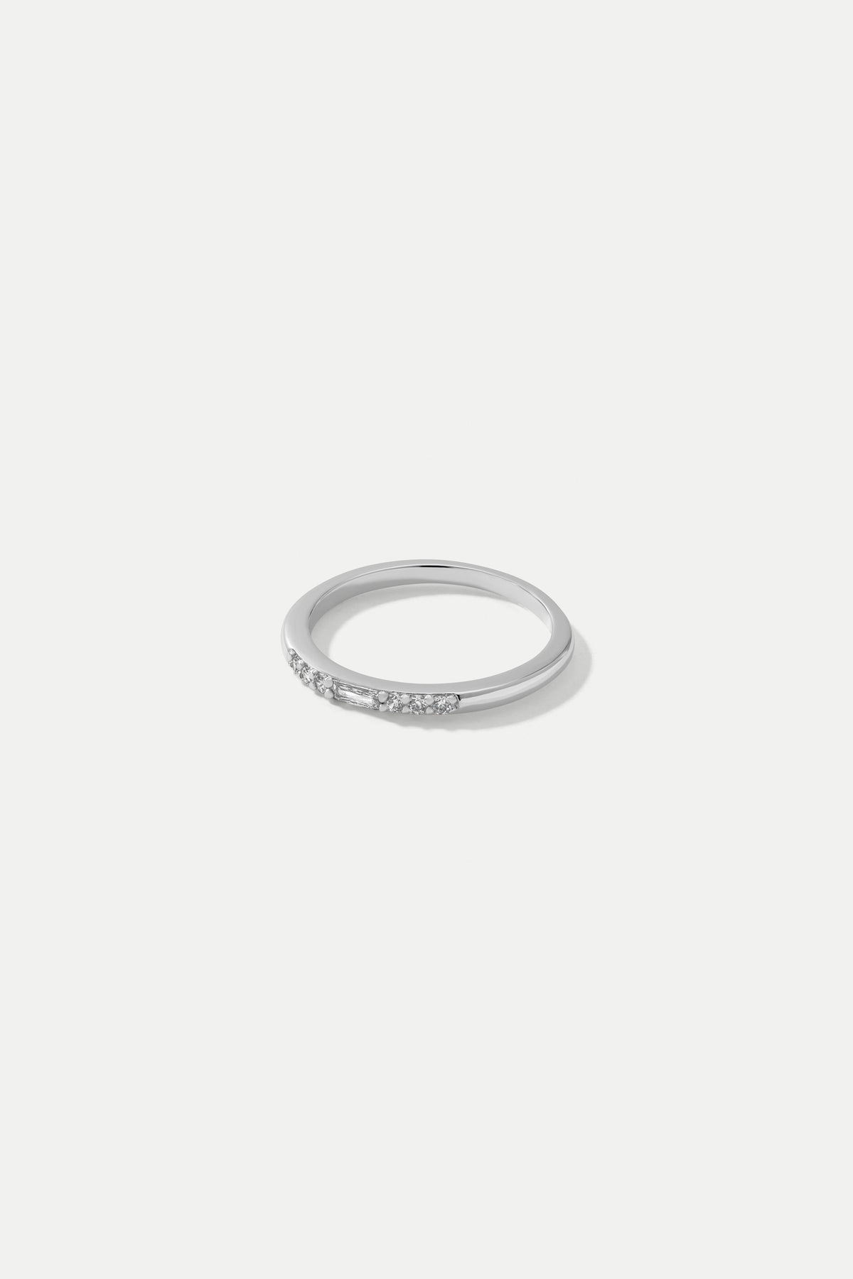 Silver Eve slim band ring set with a baguette CZ centerpiece surrounded by round CZ stones on a white background.