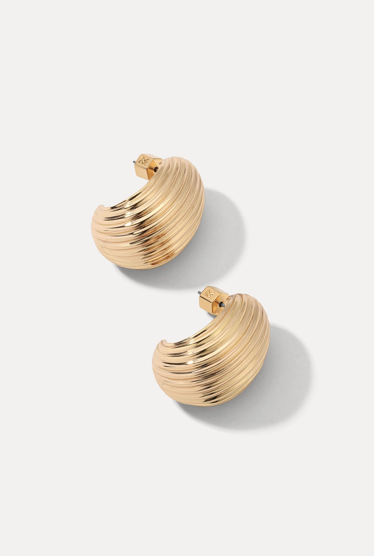 Pair of gold Florence ribbed dome hoop earrings displayed on a white backdrop