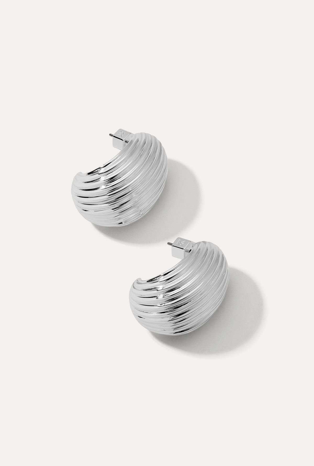 Pair of silver Florence ribbed dome hoop earrings displayed on a white backdrop