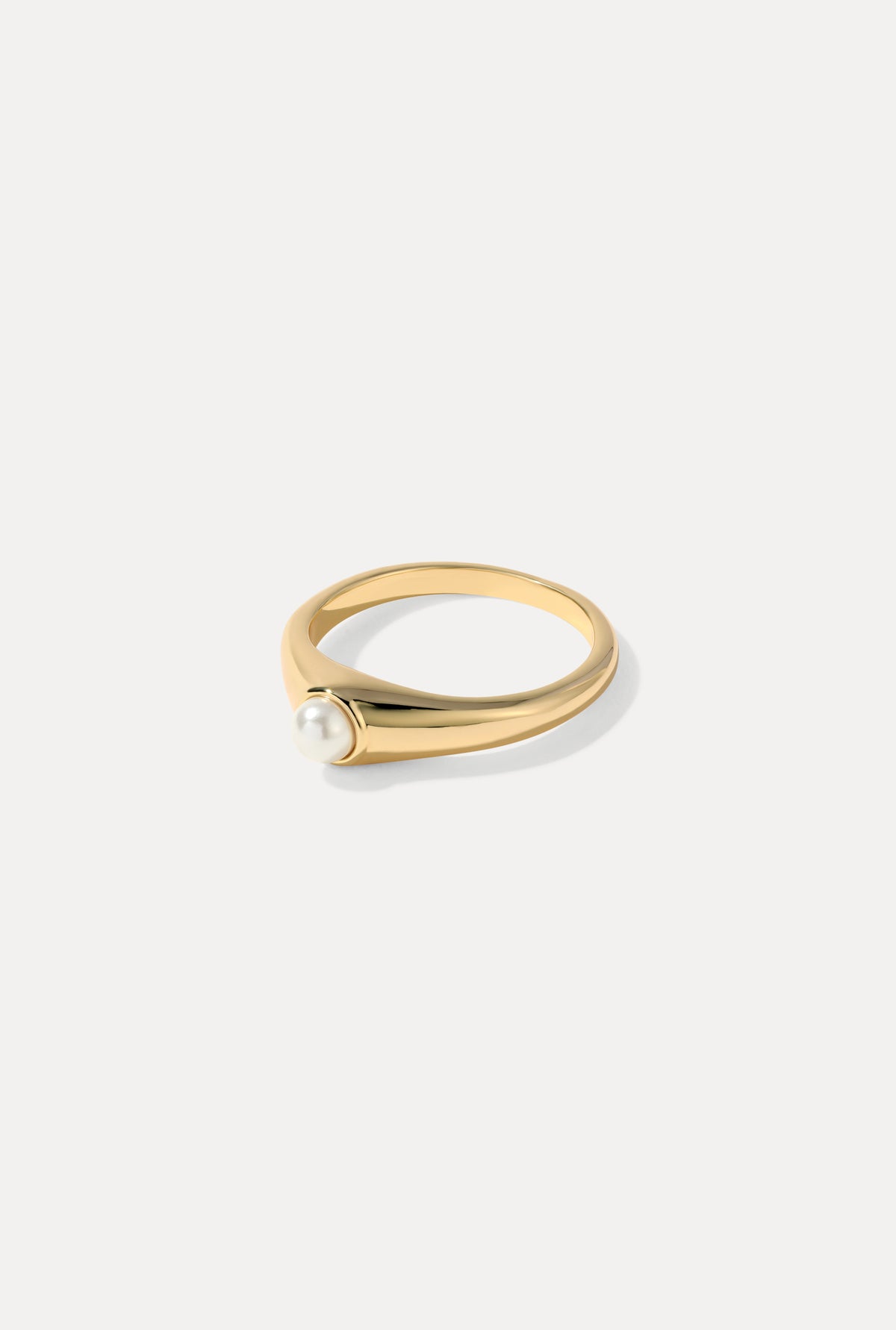 Gold Greta ring featuring a polished band and a natural pearl centerpiece on a white background.