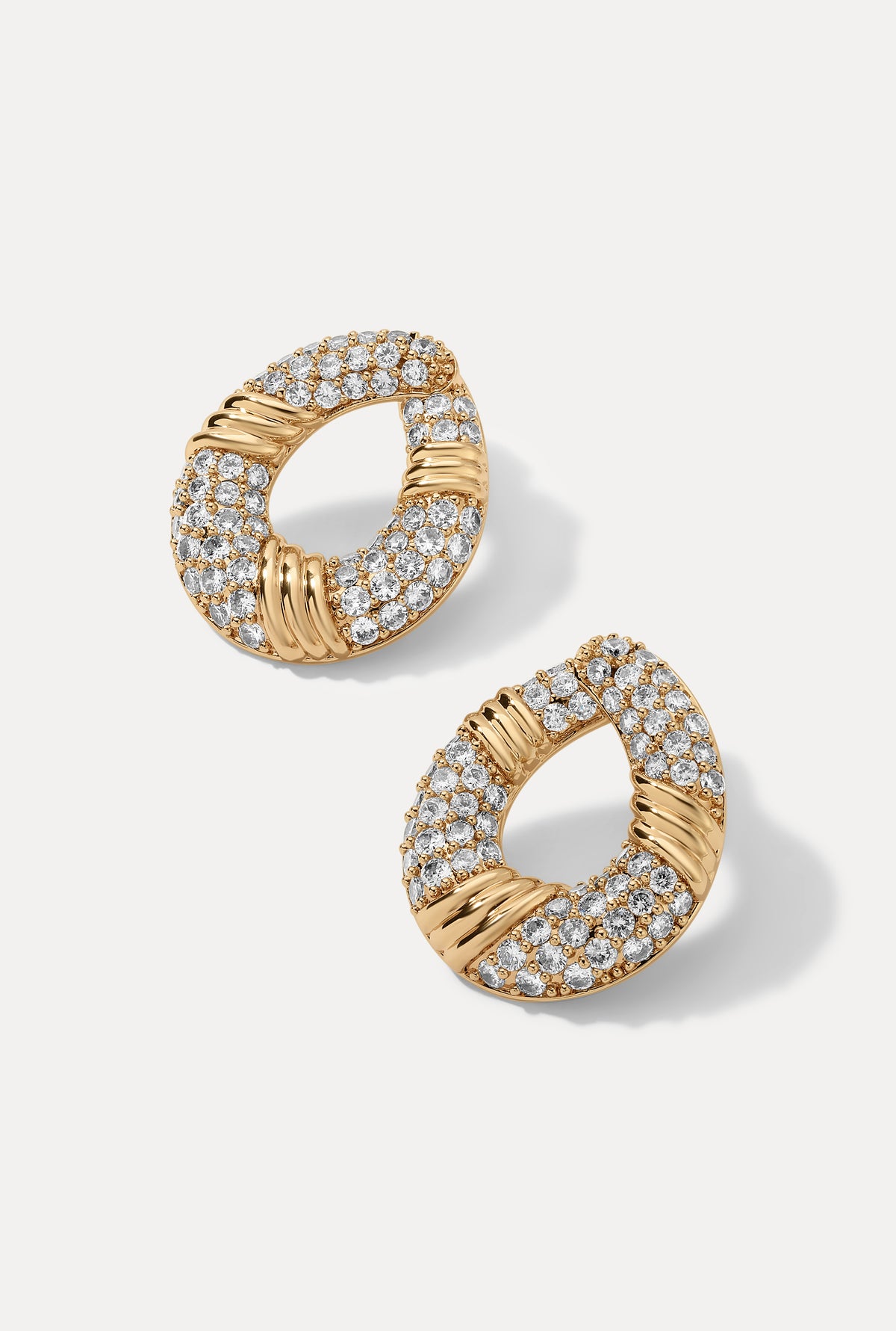 Pair of gold Halle hoop earrings with pavé CZ accents displayed on a white backdrop