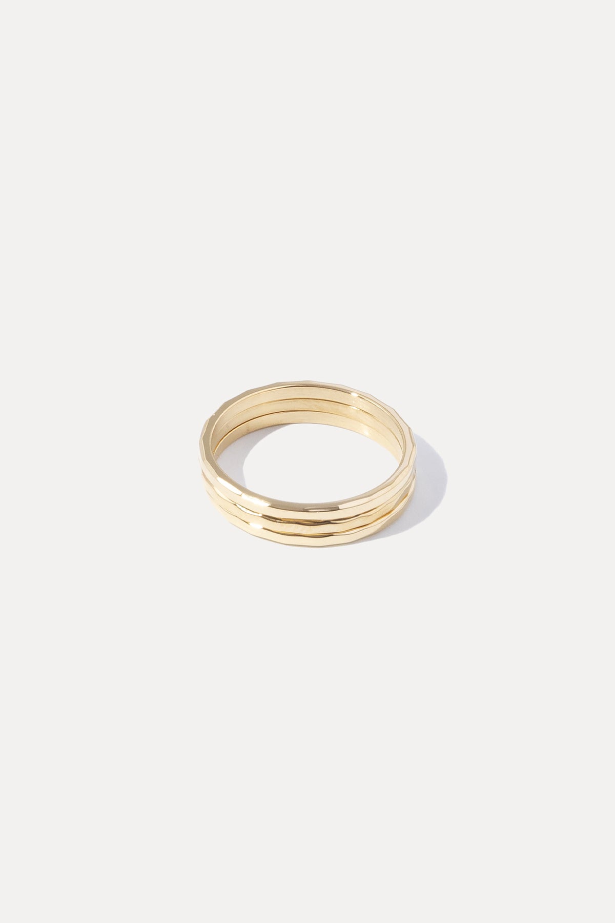 Gold Hazel Stacking Rings set featuring three slim hammered bands displayed on a white background.
