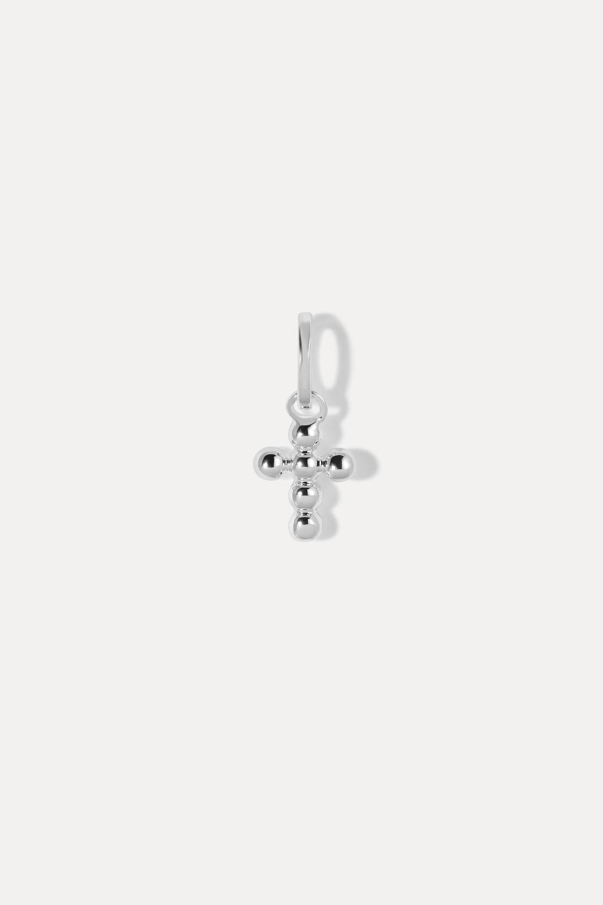 Silver beaded cross charm on a bail against a plain white background.
