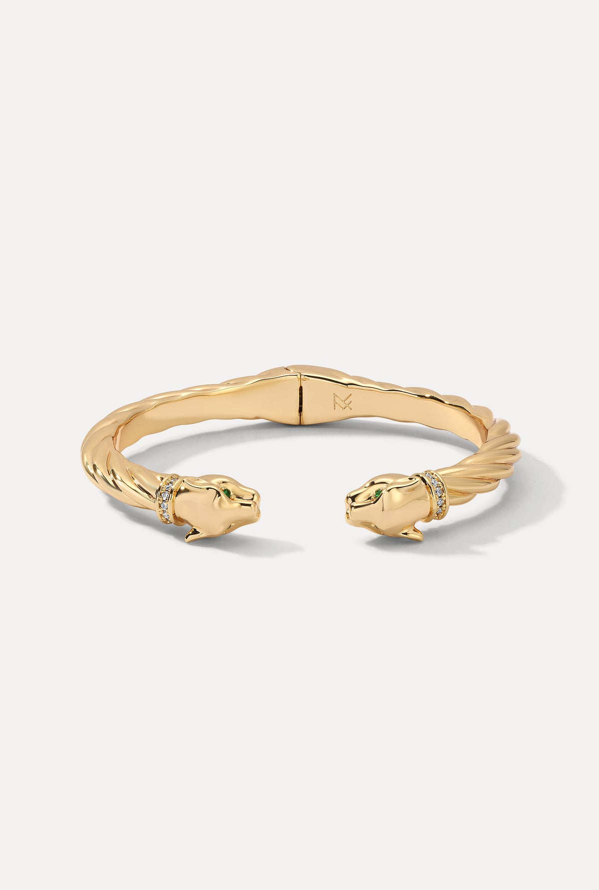 Gold twisted panther cuff bracelet with emerald eyes on white background