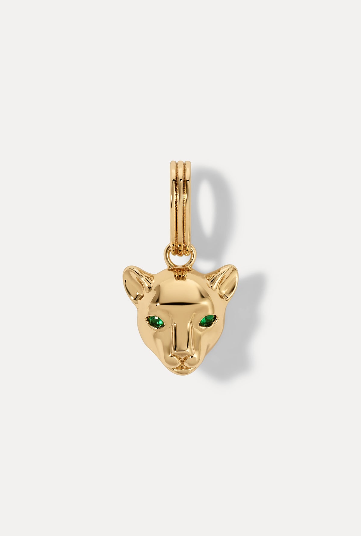 Gold panther charm with sparkling green emerald eyes on white background