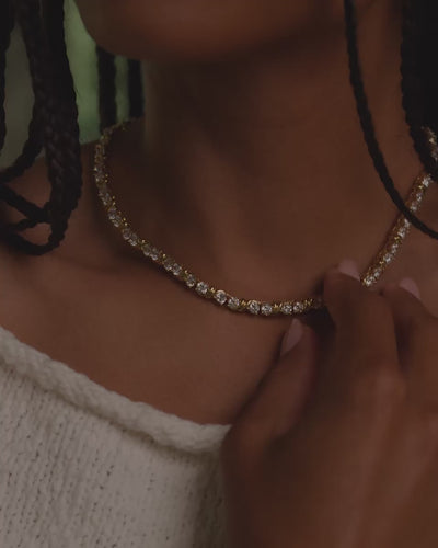 Short video of model wearing the Delilah Necklace in silver while gently touching the necklace with her hand.
