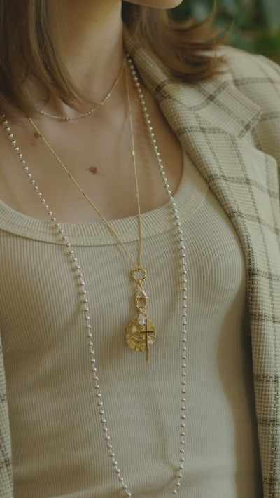 Model wearing the coco gold cable chain necklace and love charm alongside the Amelia silver necklace.