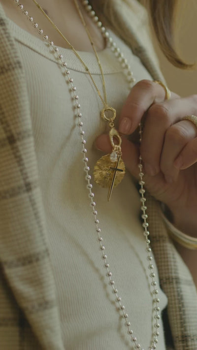 Model showcasing the Sutton, Gia, Love and petite cross charms in gold.