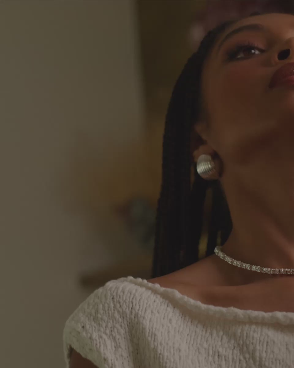 Video of a model wearing the silver Florence earrings paired with the silver Delilah necklace.