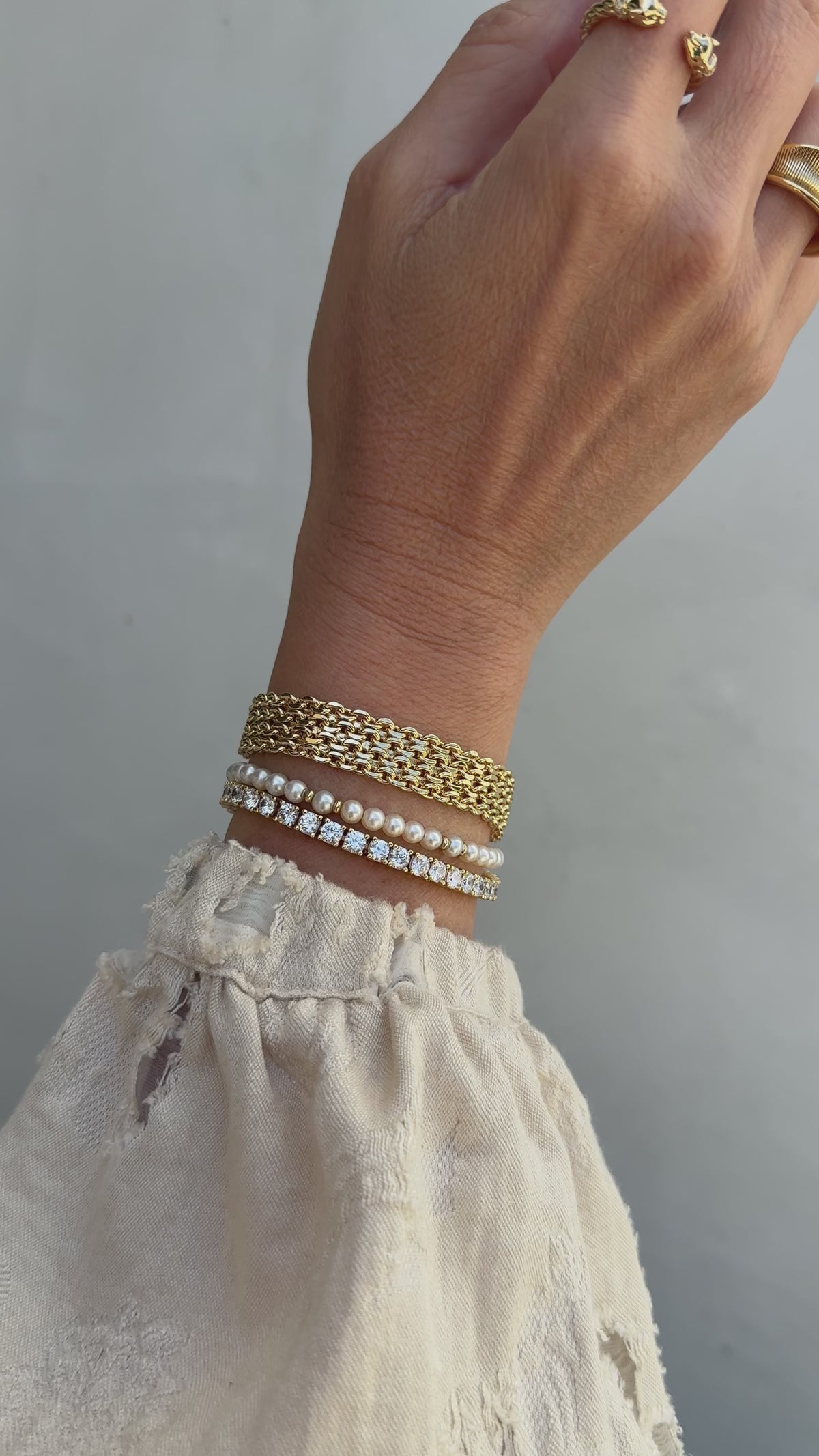Model image of a wrist stack featuring the Camryn, Bette and Audrey bracelets in gold.