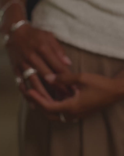 Video of a model's hand near her hip wearing the ann marie and celine rings in silver.