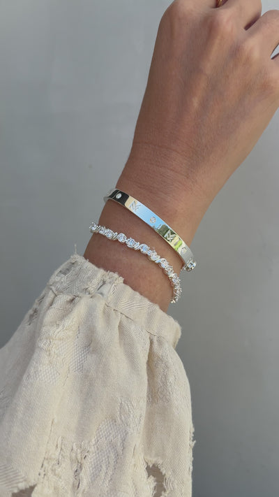 Video image of a mode's wrist wearing the best selling MF Cuff and Delilah bracelt in silver.