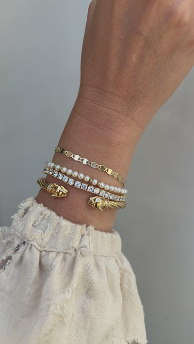 A video of a model's wrist featuring the Ava, Bette and Audrey bracelets paired with the panther cuff. 