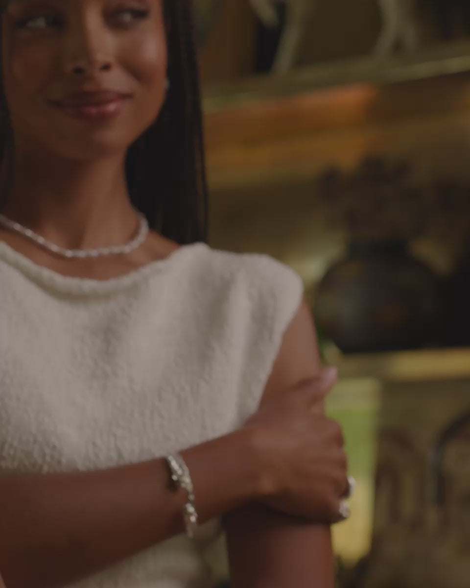 Video of a model with her hand on her arms while showcasing the silver Delilah necklace.